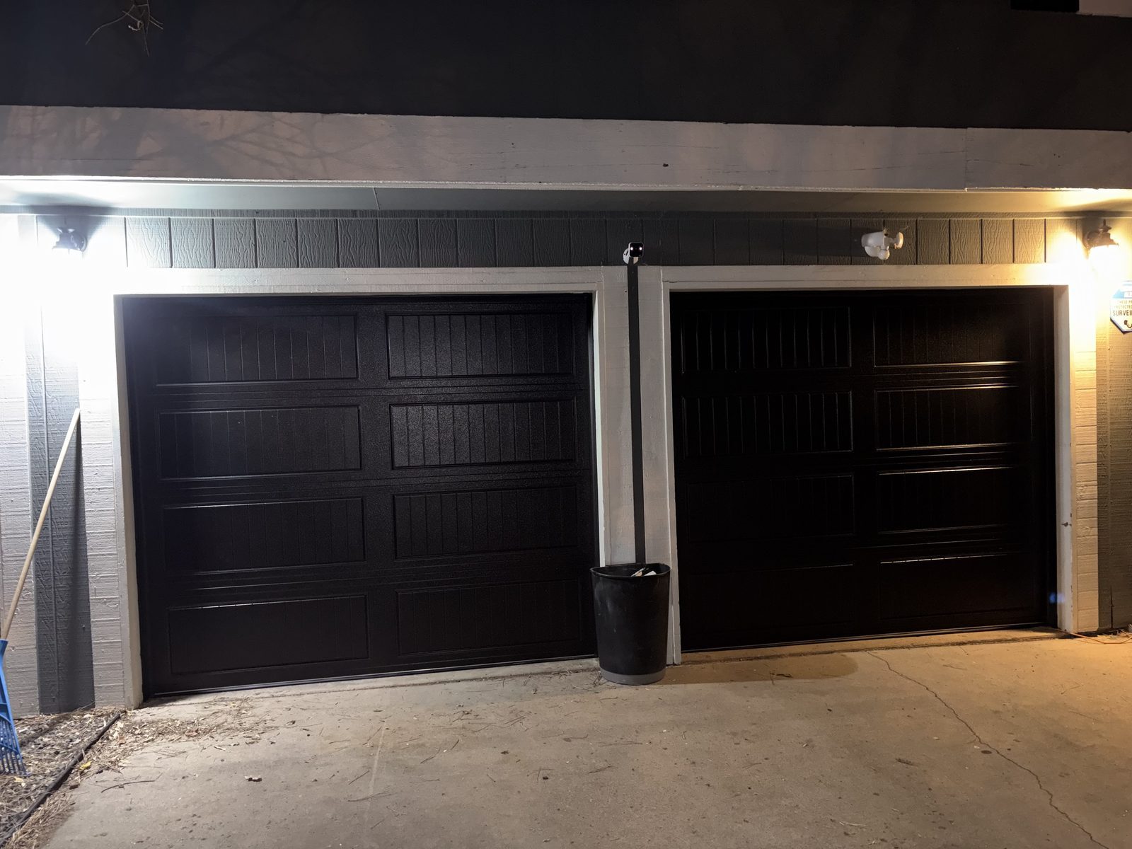 Modern black garage door installation at night in Colorado Springs